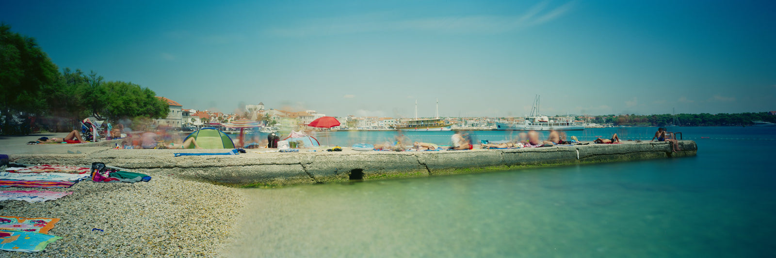 Photographie d’art d’André Wagner: Une plage de pierres dessine une courbe claire au bord de l’eau — Beach Walk 2.
