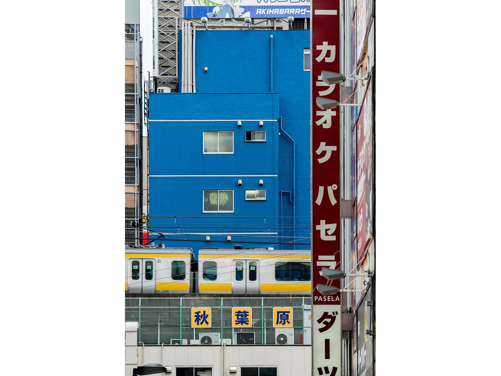 Photographie d’art d’André Wagner: Un mur d’un bleu intense domine le format vertical étroit — Cityscape tokyo 1, Japan.