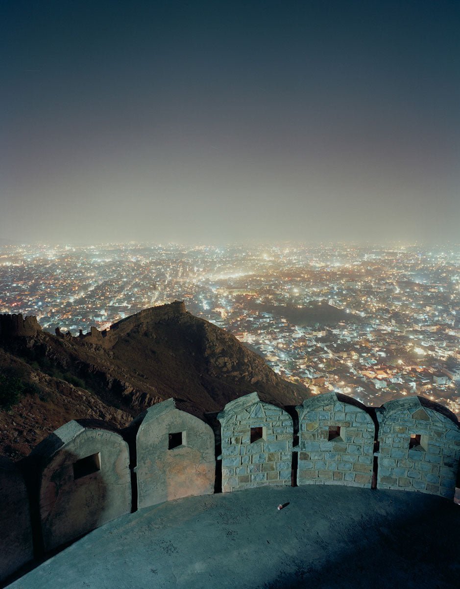 Photographie d’art d’André Wagner: Un parapet bas aux créneaux arrondis coupe le bord inférieur du format vertical — Cup of Jaipur, Indien.