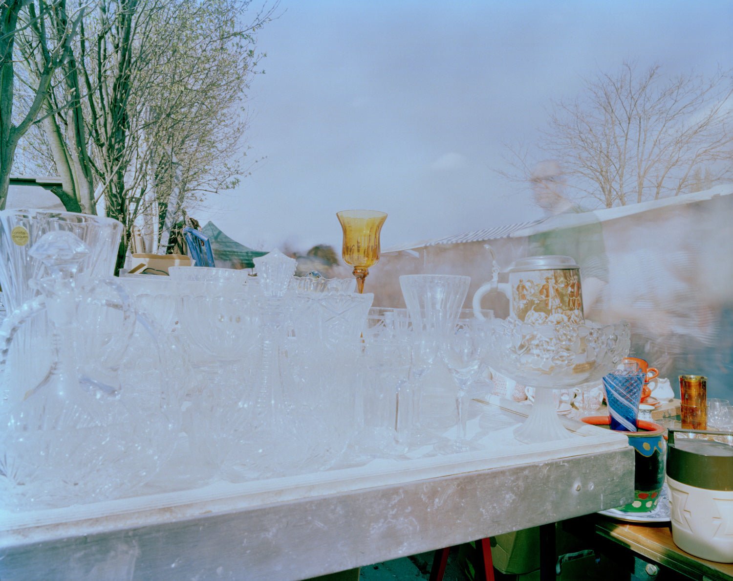 Photographie d’art d’André Wagner: Des verres et des récipients clairs sont serrés sur un étal horizontal — Flea Market, Deutschland.