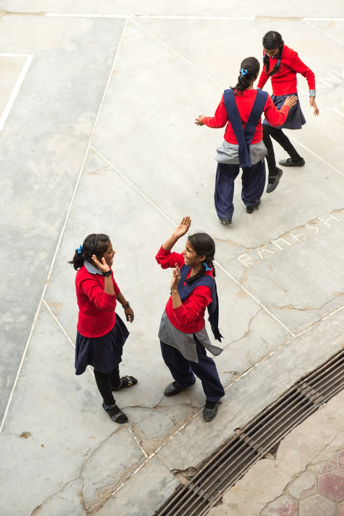 Photograph of a group wearing red tops on a pale paved space
