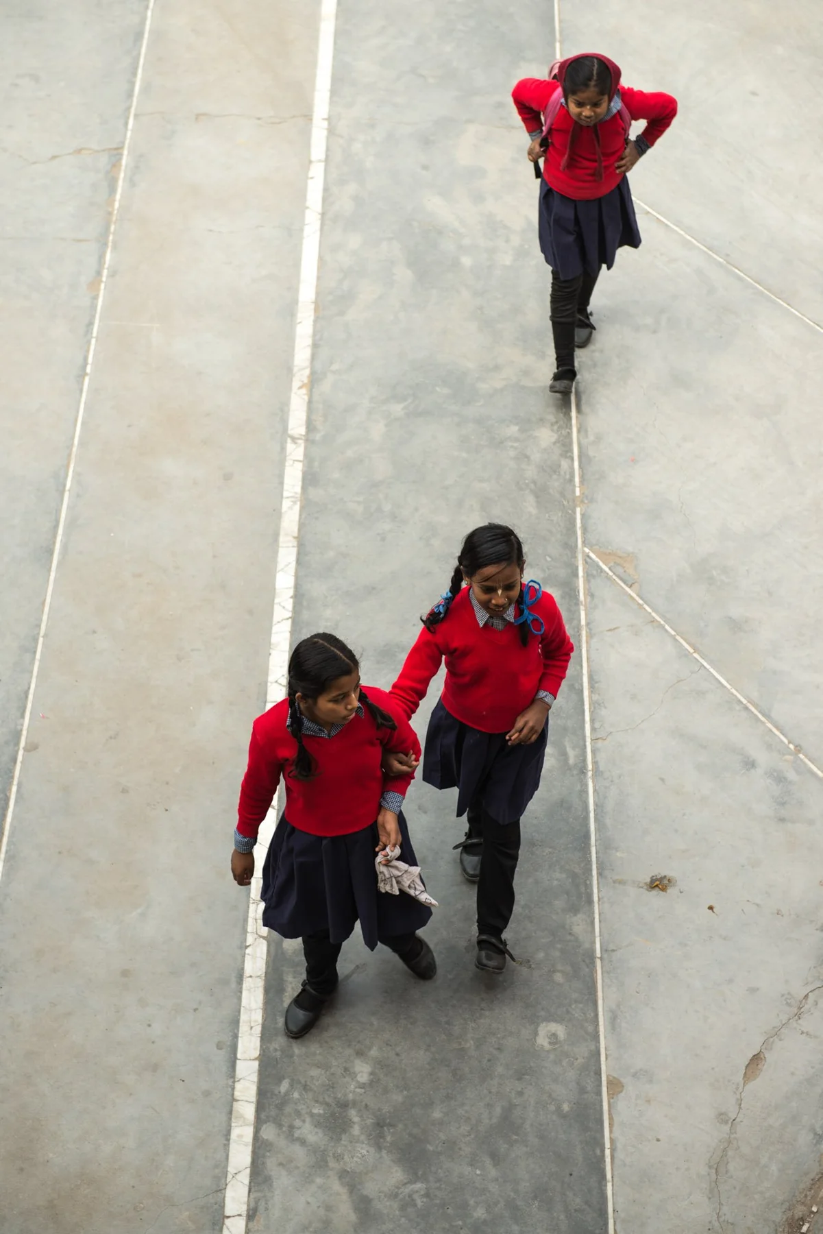 Photograph of a group wearing red tops on a pale paved space