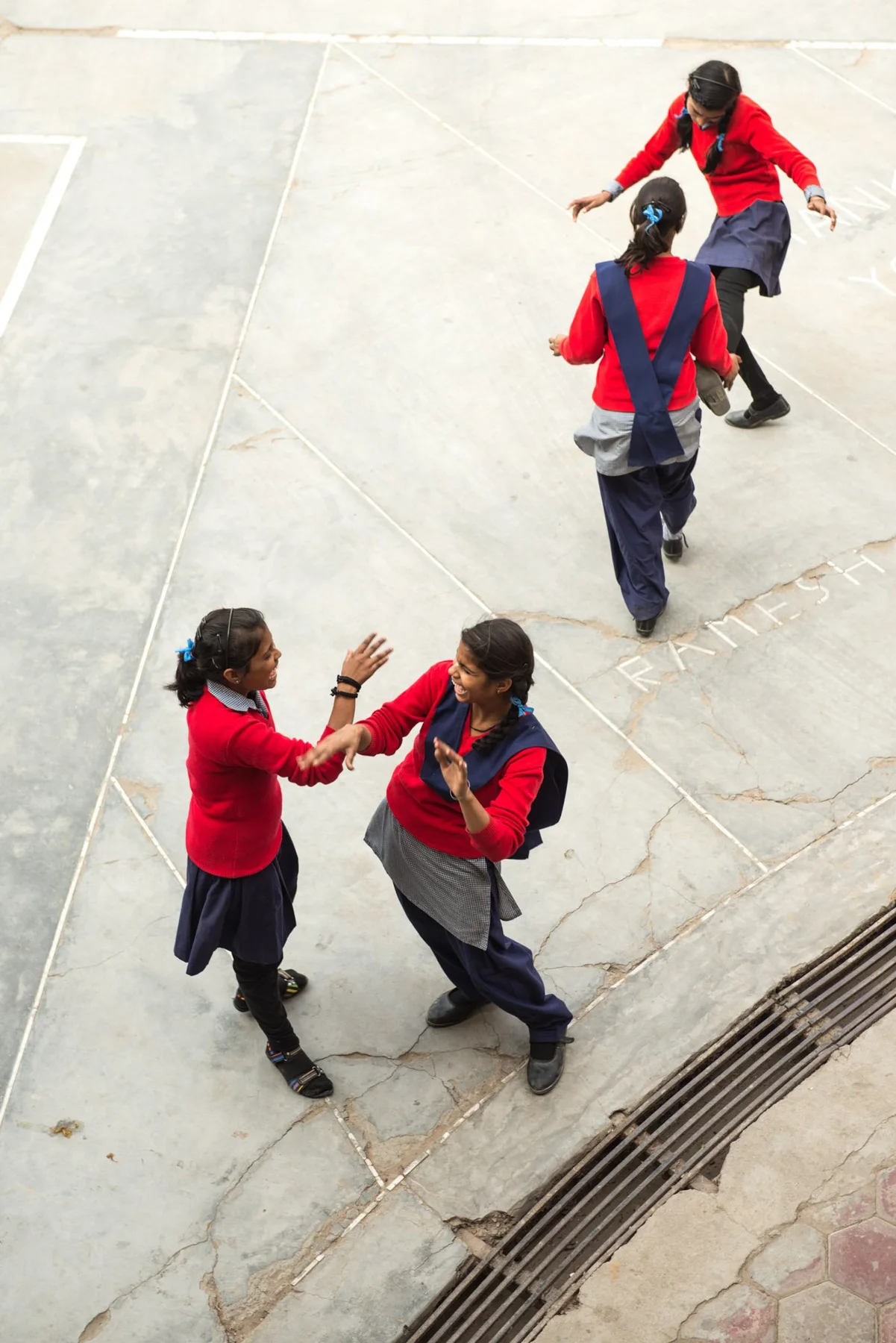 Photograph of a group wearing red tops on a pale paved space