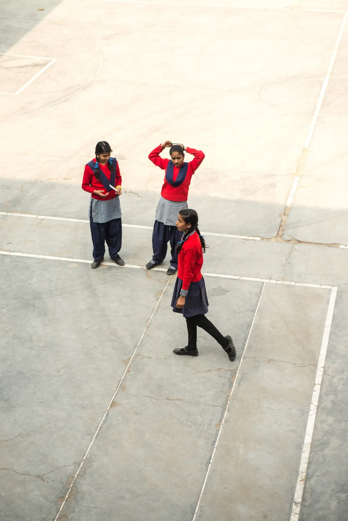 Photograph of a group wearing red tops on a pale paved space