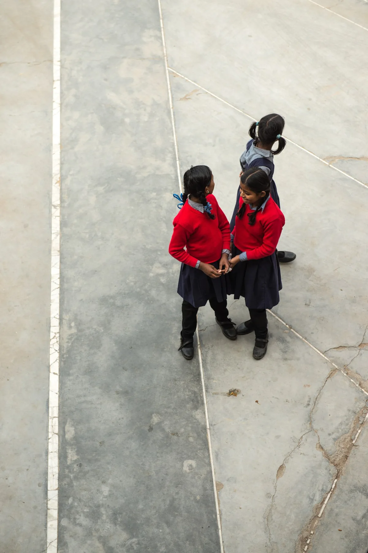 Photograph of a small group on a pale paved space, seen from above