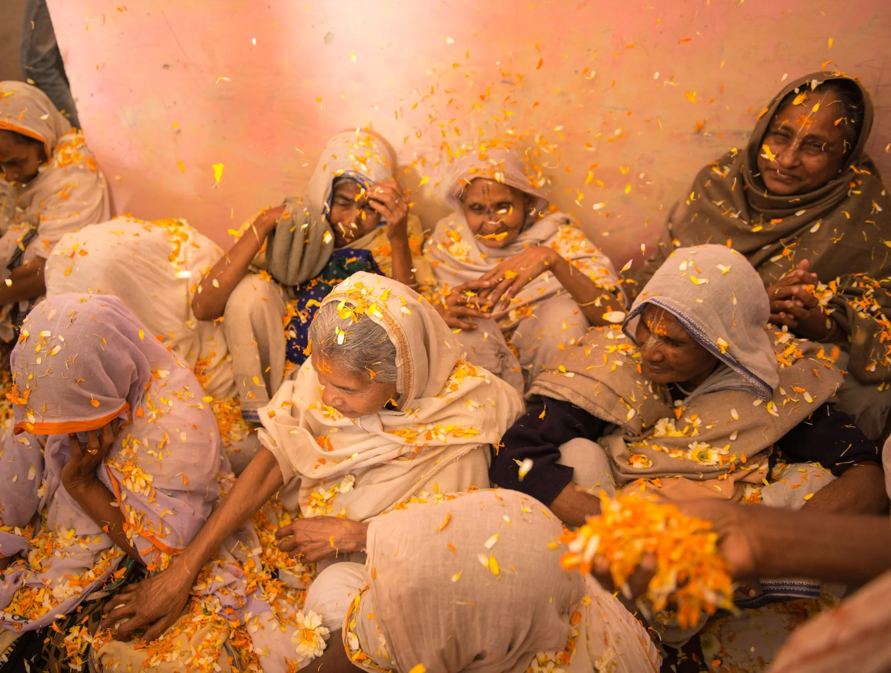 Photograph of a seated group with coloured powder on clothes and faces
