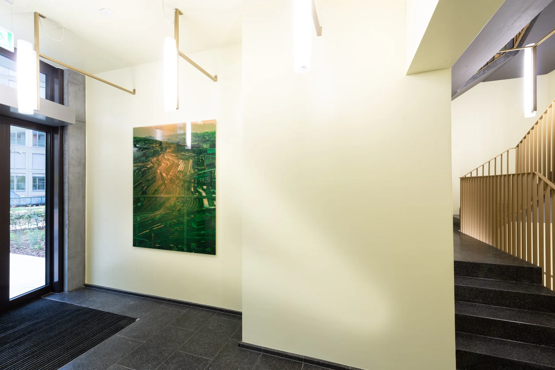 Œuvre photographique aux traînées lumineuses vertes et dorées dans un intérieur