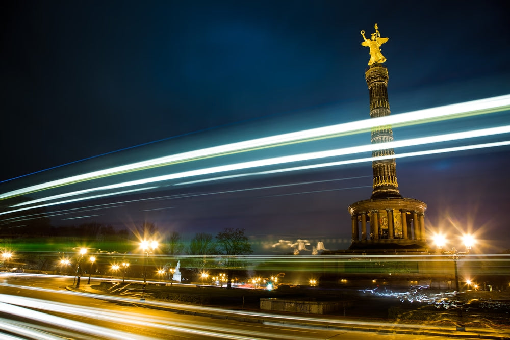 Fine art photography by André Wagner: A tall column topped by a golden figure stands against night sky — Golden Nights - Nothing Else.