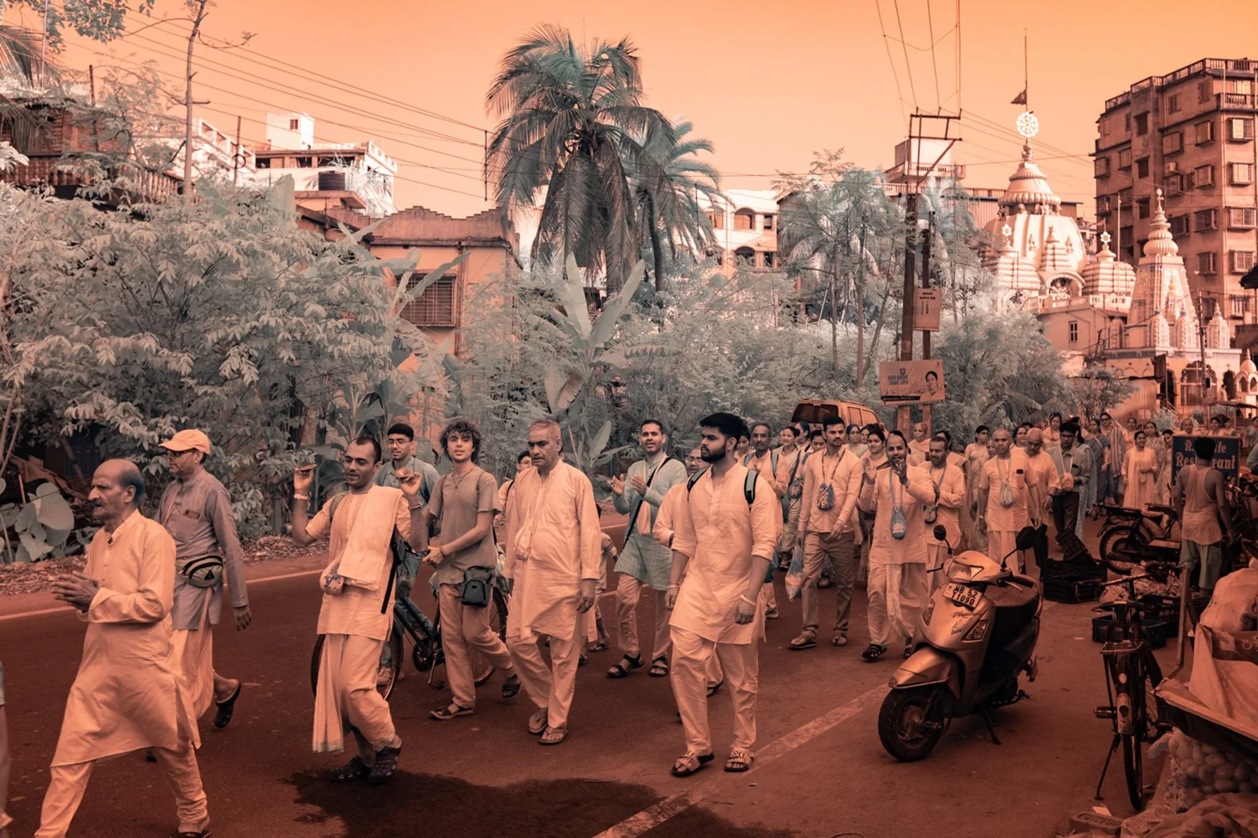 Groupe de personnes en procession entre des bâtiments.