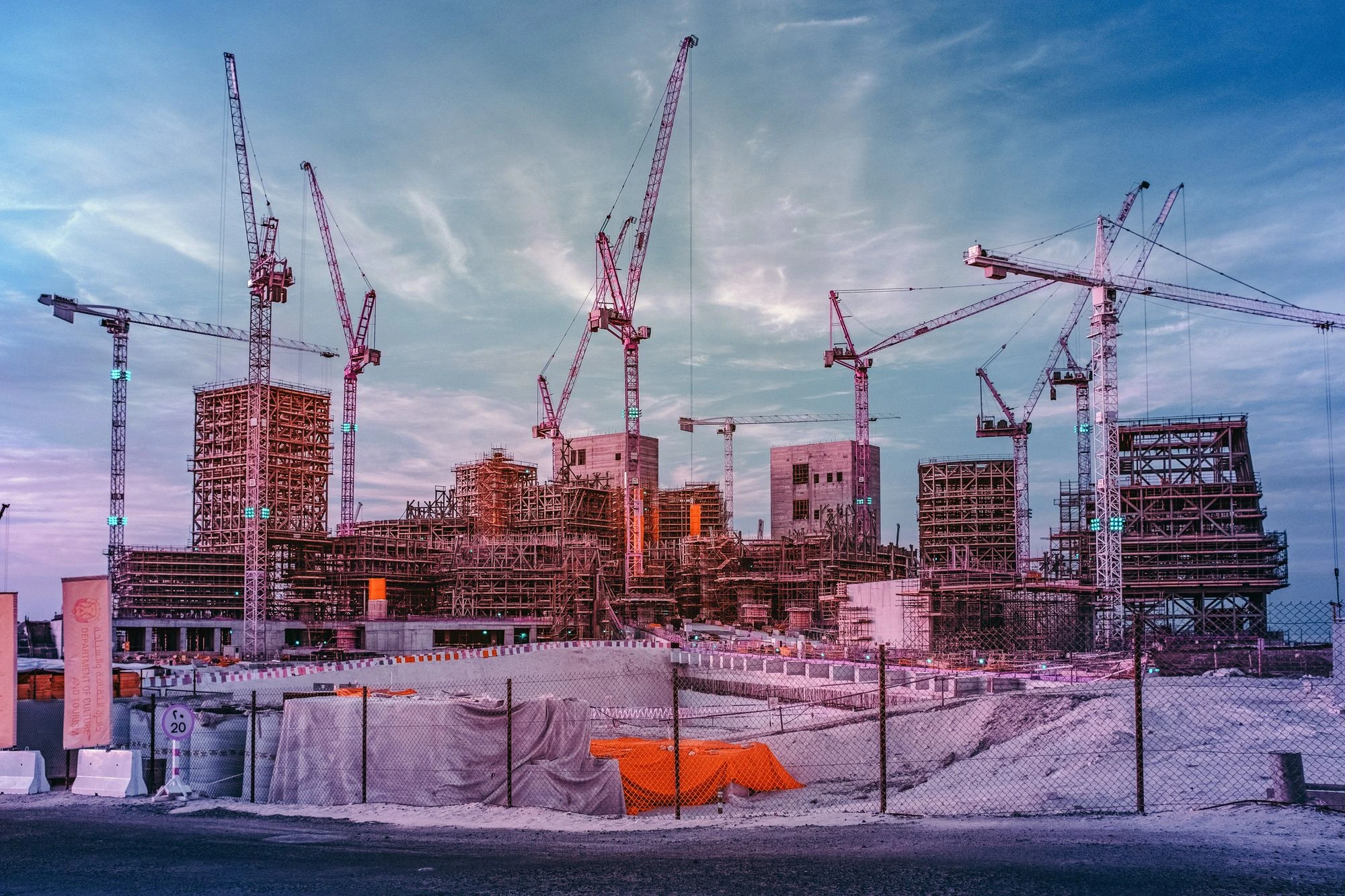 Photographie d&rsquo;art infrarouge d&rsquo;Andr&eacute; Wagner: De nombreuses grues traversent le ciel au-dessus d&rsquo;un vaste chantier &mdash; Guggenheim Abu Dhabi &ndash; Under Construction.