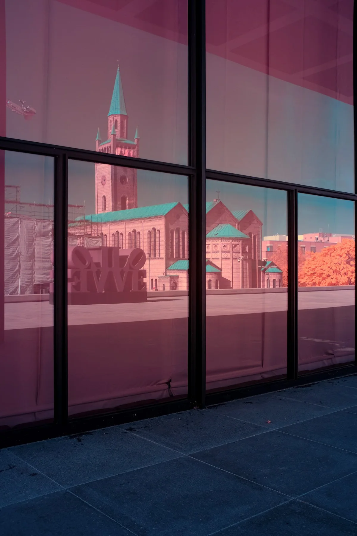 Une église historique se reflète dans une façade de verre.
