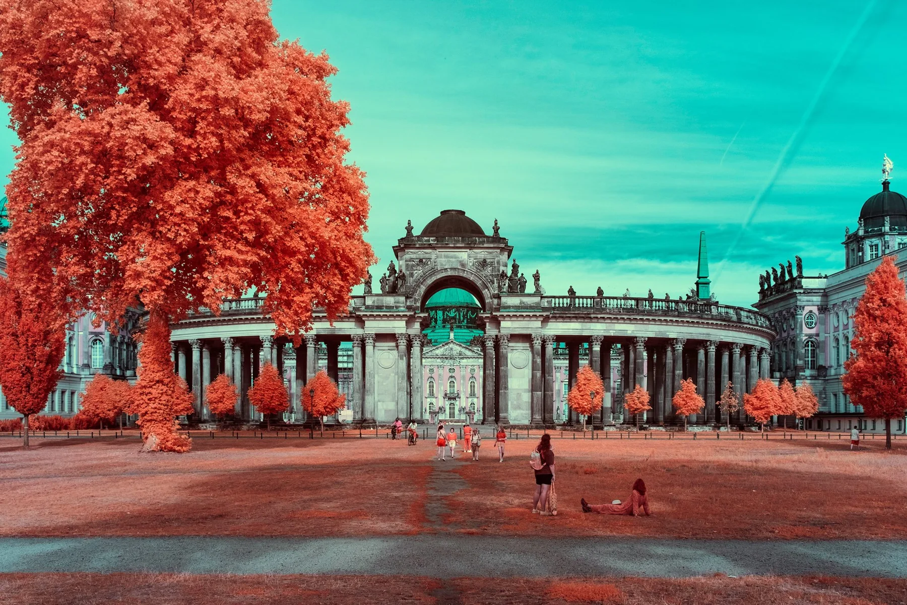 Porte monumentale historique derrière un arbre orange.