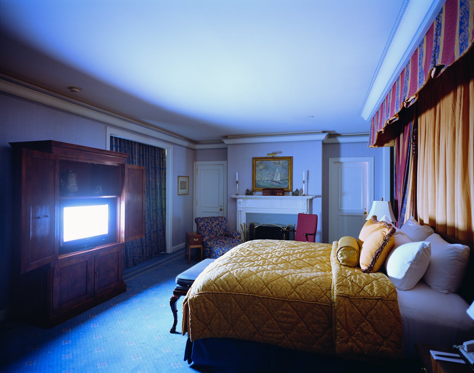 Fine art photography by Andr&eacute; Wagner: A bed with a gold cover occupies the right half &mdash; Hotel Room in New York 1.
