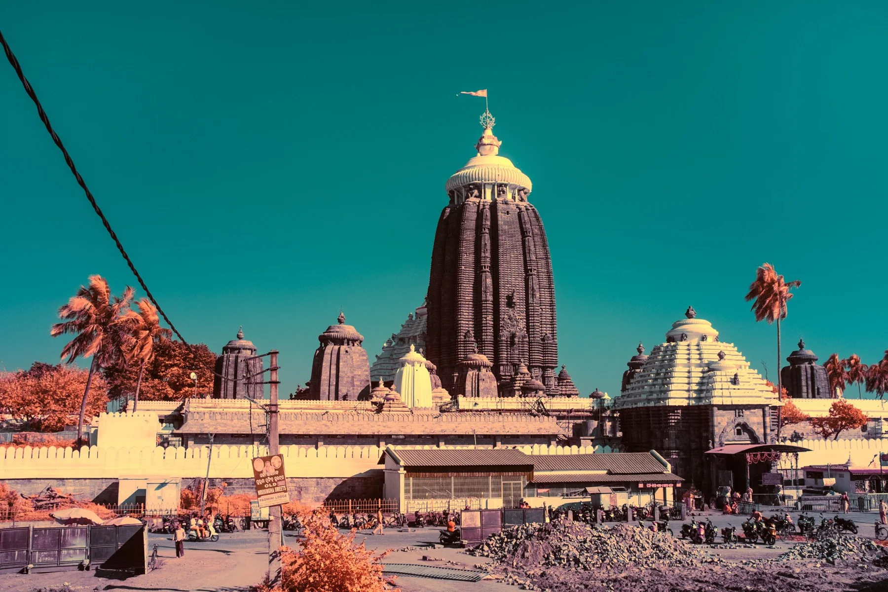 Infrared fine art photograph of a temple complex against a turquoise sky