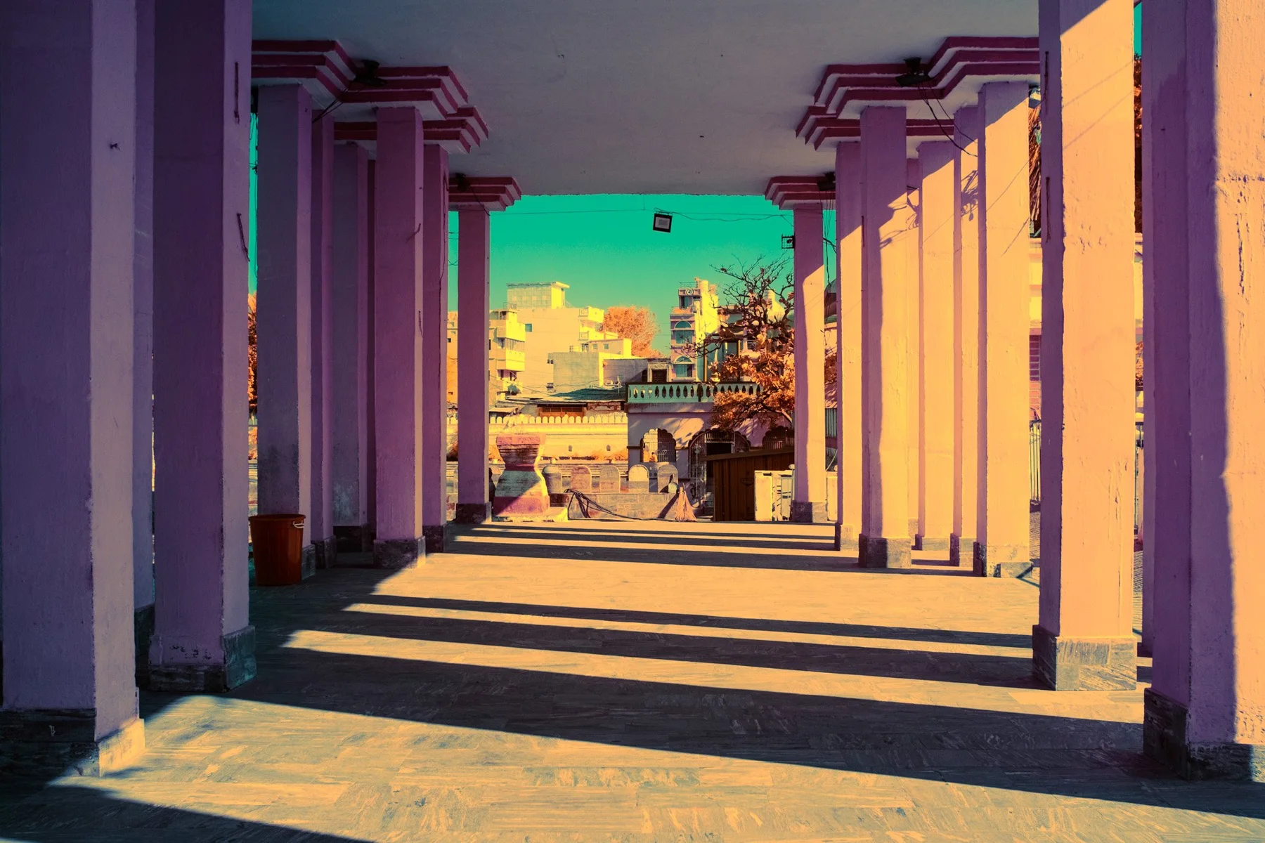 Infrared fine art photograph of a colonnade with violet shadows