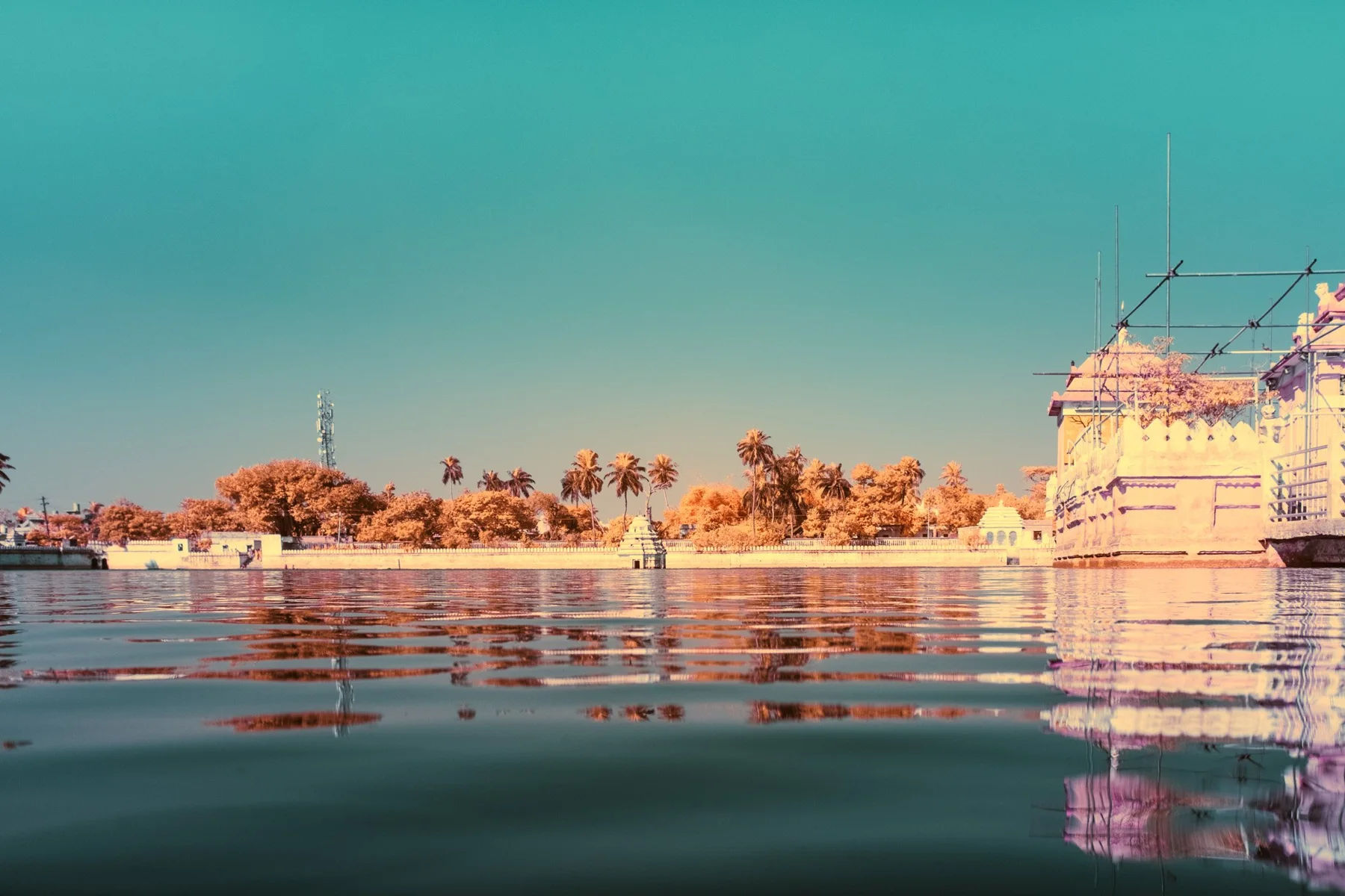 Infrared fine art photograph of a pool with architecture and palm trees along its edge