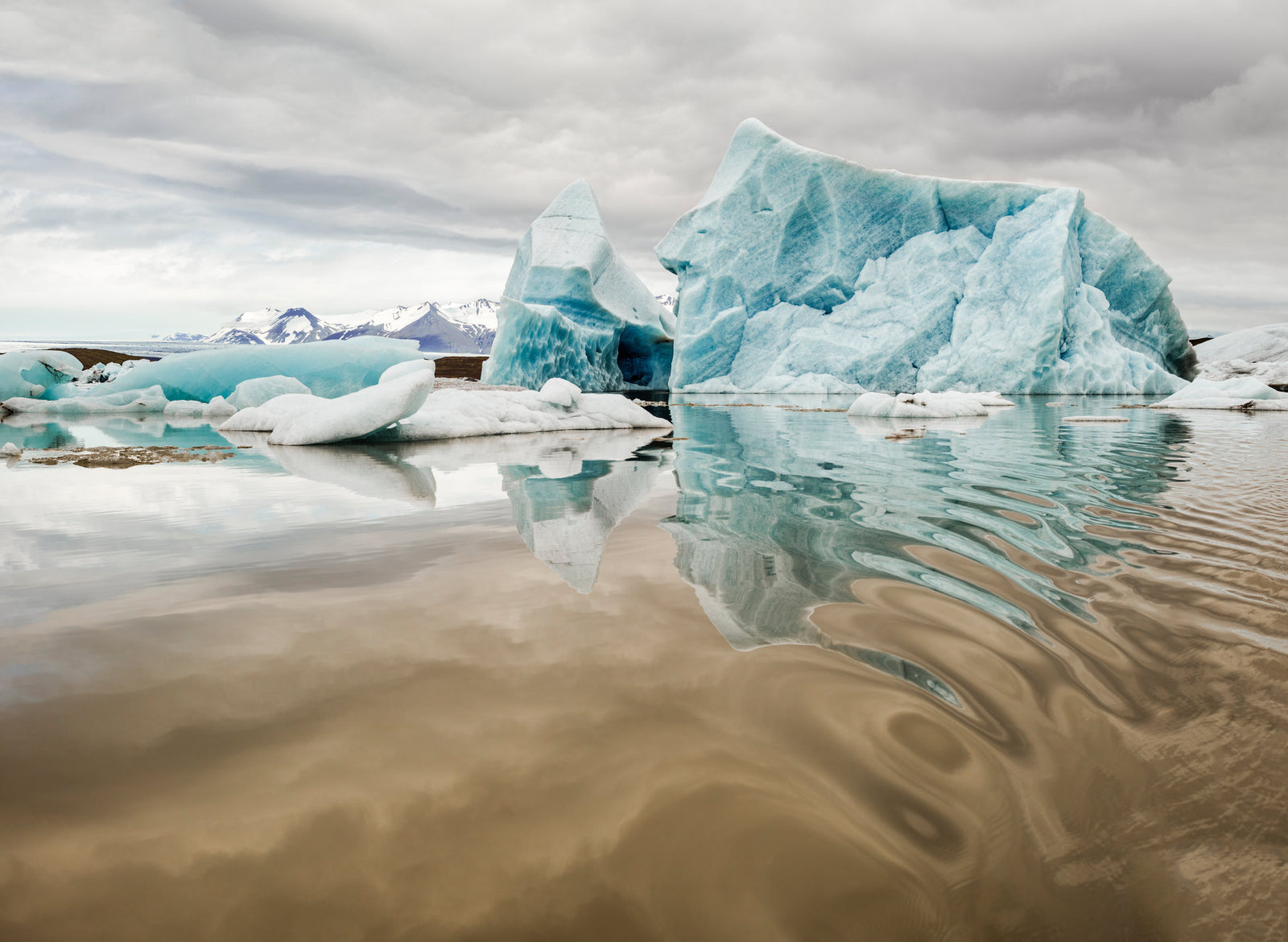 Photographie d’art d’André Wagner: Un grand bloc de glace bleu s’élève à droite au-dessus de la ligne d’eau — Jökulsárlòn glacier lagoon 1, Island.