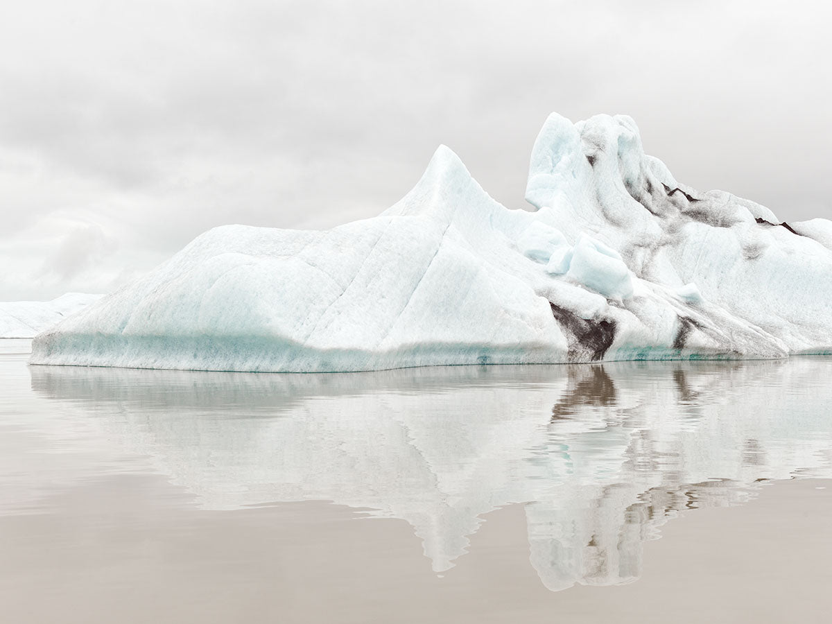 Photographie d’art d’André Wagner: Des formes de glace claires s’élèvent en gradins pointus et arrondis au-dessus d’une eau calme — Jökulsárlòn glacier lagoon 2, Island.