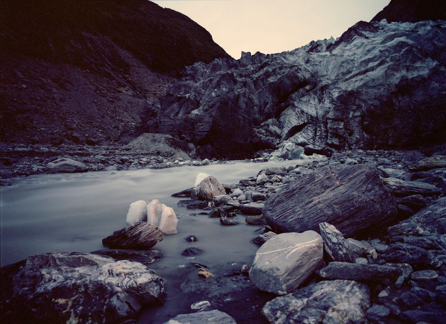 Photographie d’art d’André Wagner: Des parois rocheuses sombres encadrent une masse de glace claire et fortement accidentée — Moving Landscape.