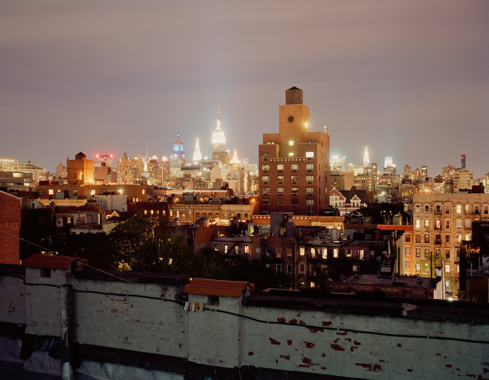 Fine art photography by Andr&eacute; Wagner: A worn low parapet crosses the foreground &mdash; NY Roof 2, USA.