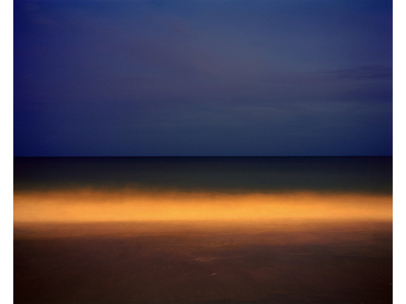 Photographie d’art d’André Wagner: Une bande orangée traverse horizontalement une surface par ailleurs bleu sombre et brune — Orange wave, Usa.