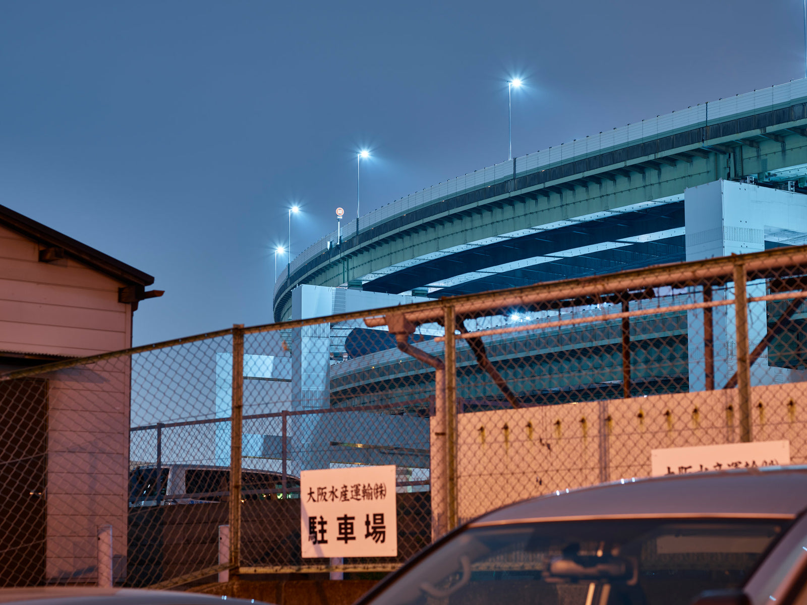 Photographie d’art d’André Wagner: Une route surélevée dessine une courbe vers la droite sous un ciel bleu — Osaka 5.