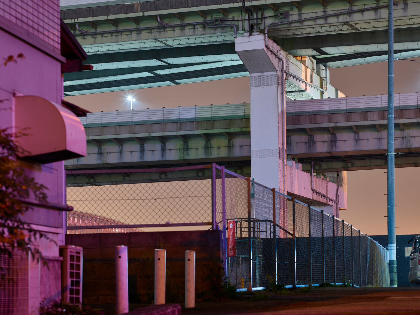 Fine art photography by André Wagner: Broad roadway beams stack above one another on massive piers — Osaka 6.