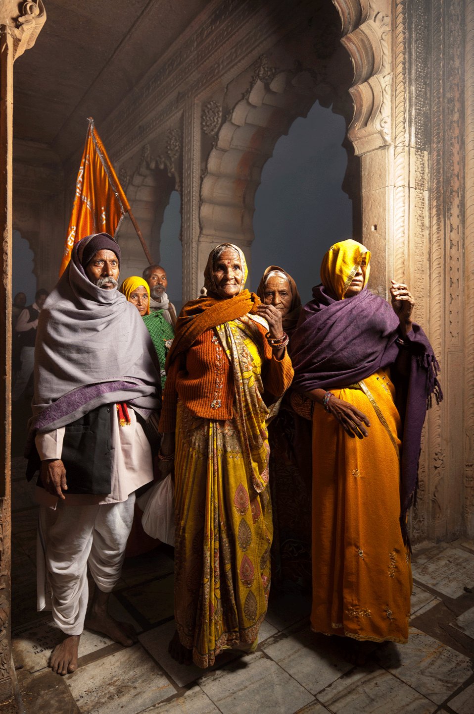 Photographie d’art d’André Wagner: Plusieurs personnes se tiennent proches les unes des autres sous une arche de pierre — Pilgrim family, Indien.