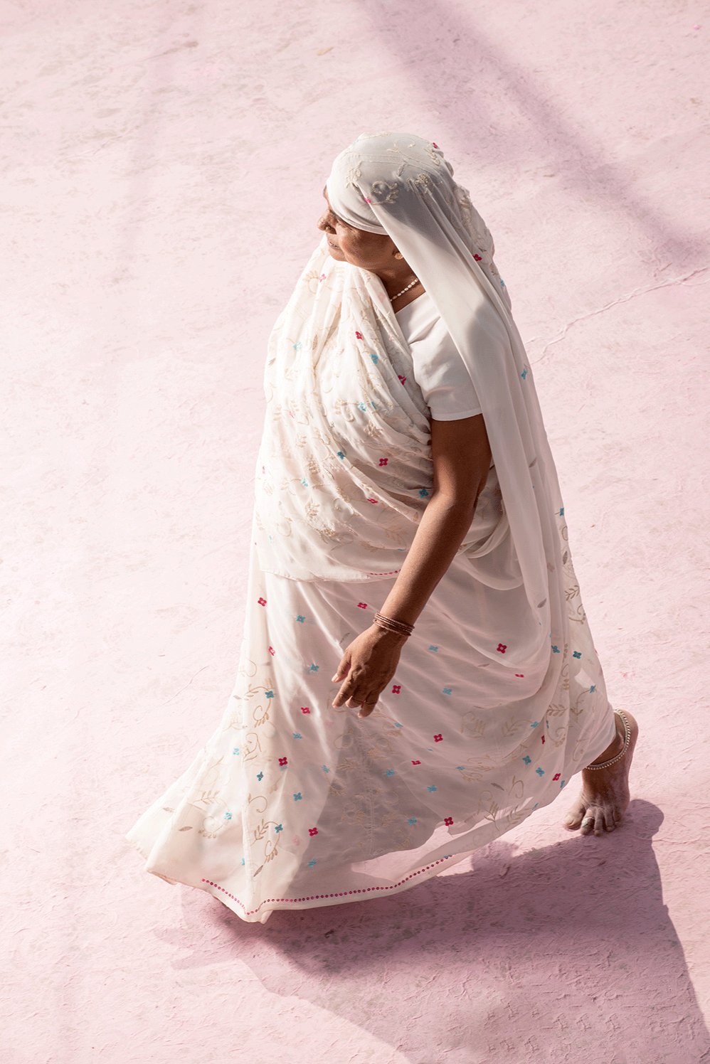 Photographie d’art d’André Wagner: Un sari blanc se détache nettement d’un sol teinté de rose et de violet — Pilgrim on purple dust 3, Indien.