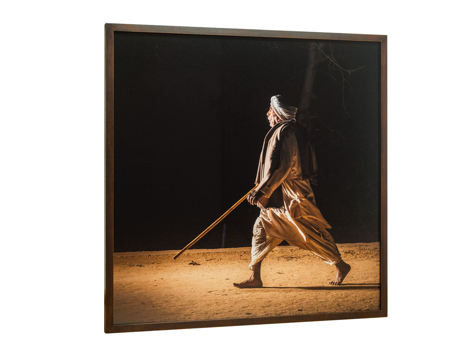 Photographie d’art d’André Wagner: Un homme coiffé d’un tissu clair avance à grands pas sur le sol éclairé — Pilgrims at govardhan 1, Indien.