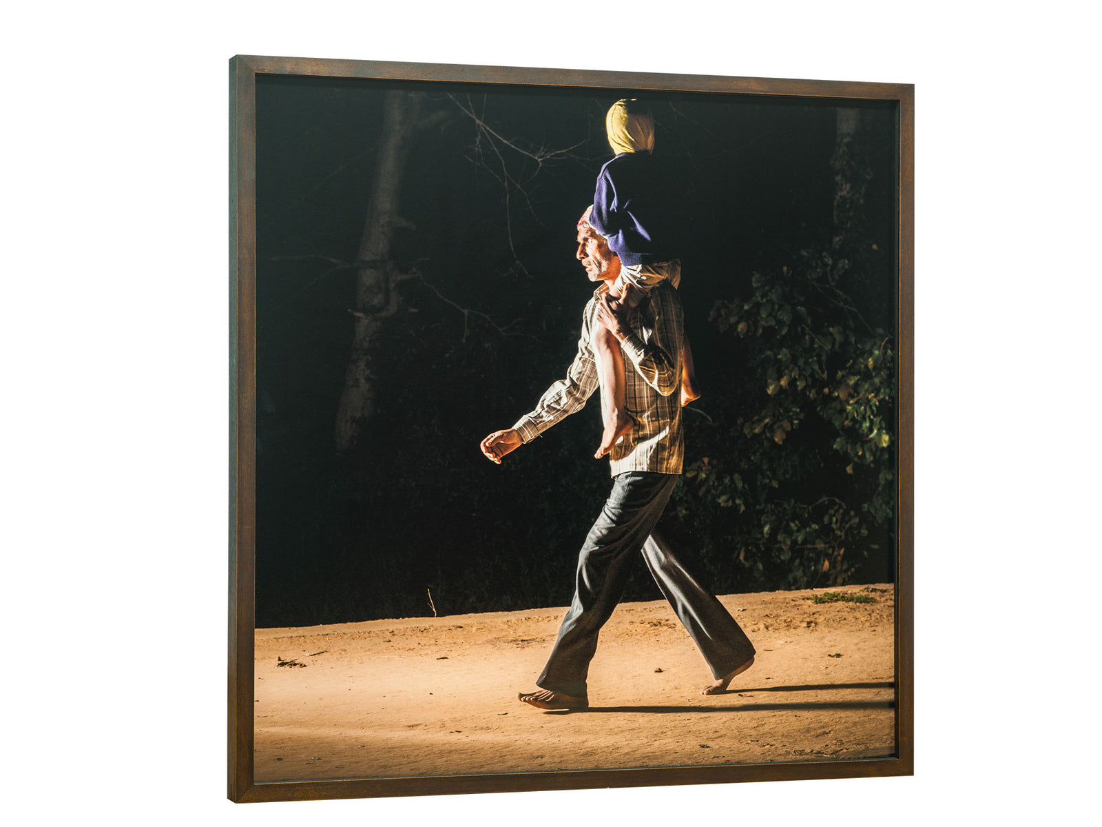 Photographie d’art d’André Wagner: Un adulte porte un enfant sur ses épaules en traversant un chemin clair — Pilgrims at govardhan 11, Indien.