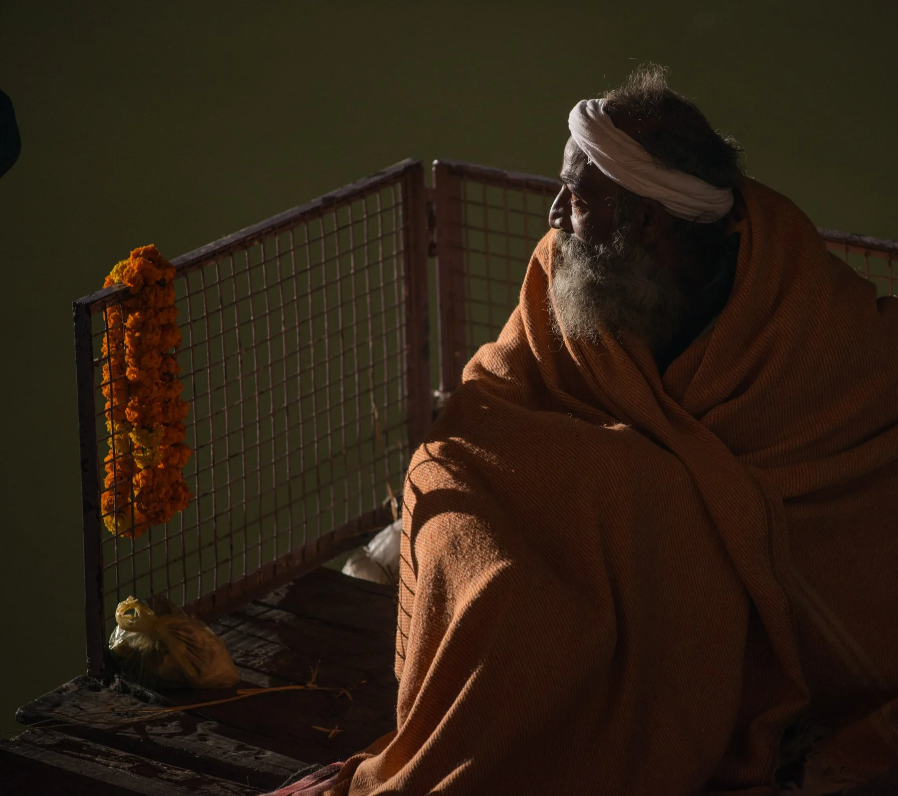 Portrait of a man wrapped in an orange ceiling at night.