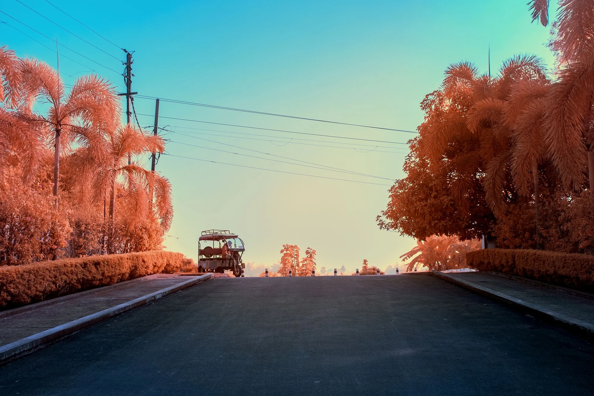 Photographie d’art infrarouge d’André Wagner: La route sombre monte vers une crête et disparaît derrière elle — Rickshaw - Gaura Village.