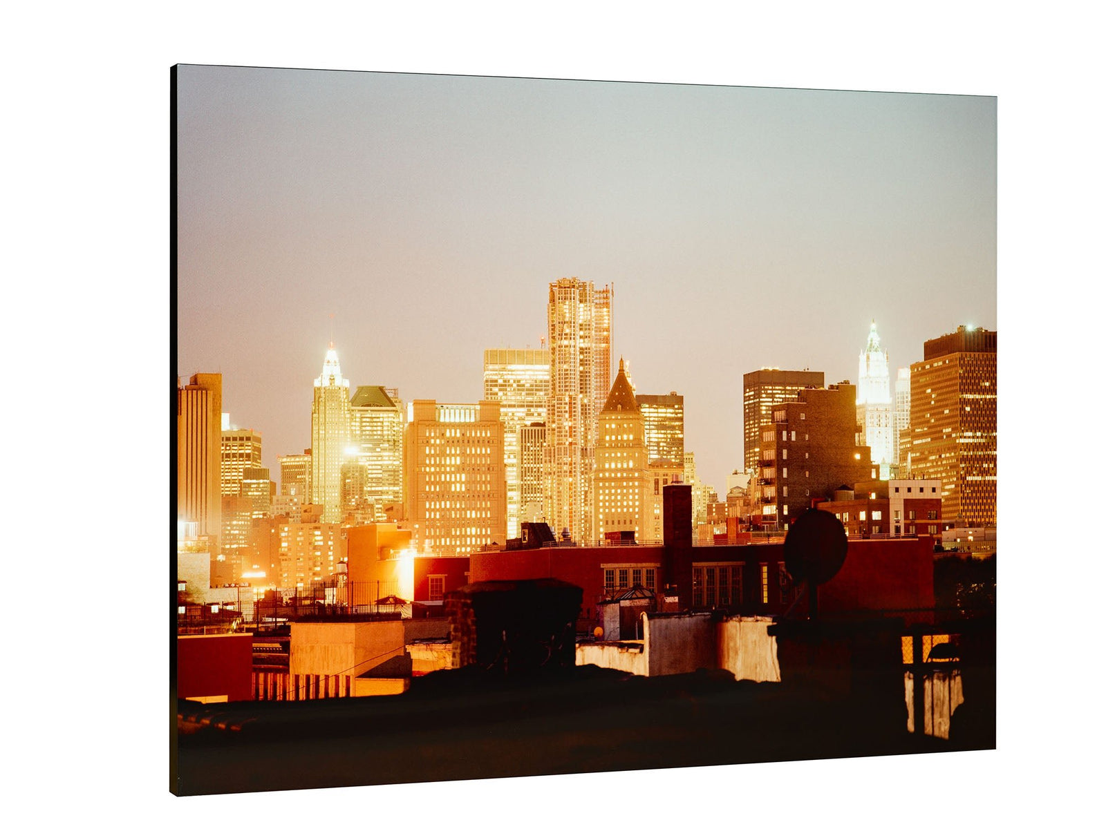 Fine art photography by André Wagner: Illuminated towers rise behind a dark zone of roofs and rooftop structures — Room of business, Usa.