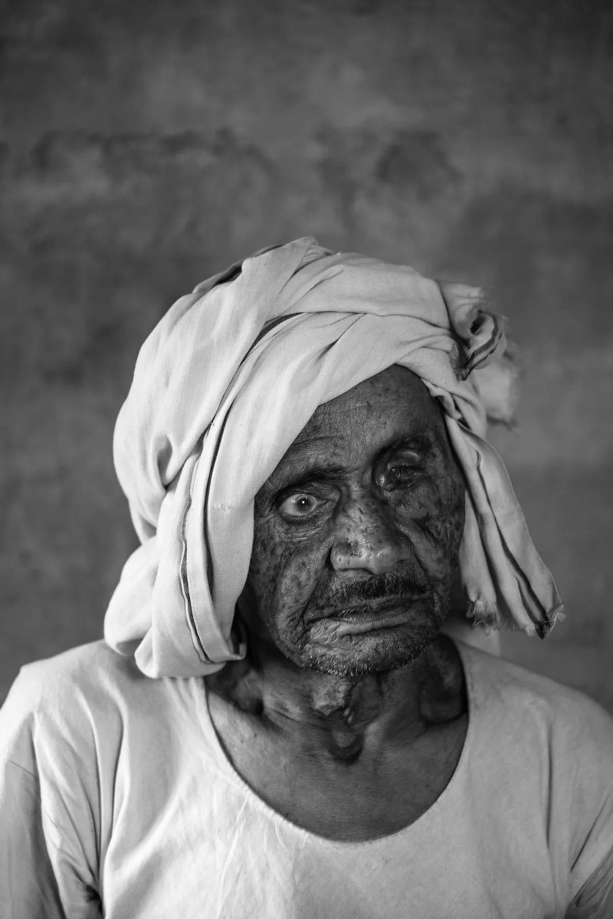 Black and white close-up portrait of a man with a turban.