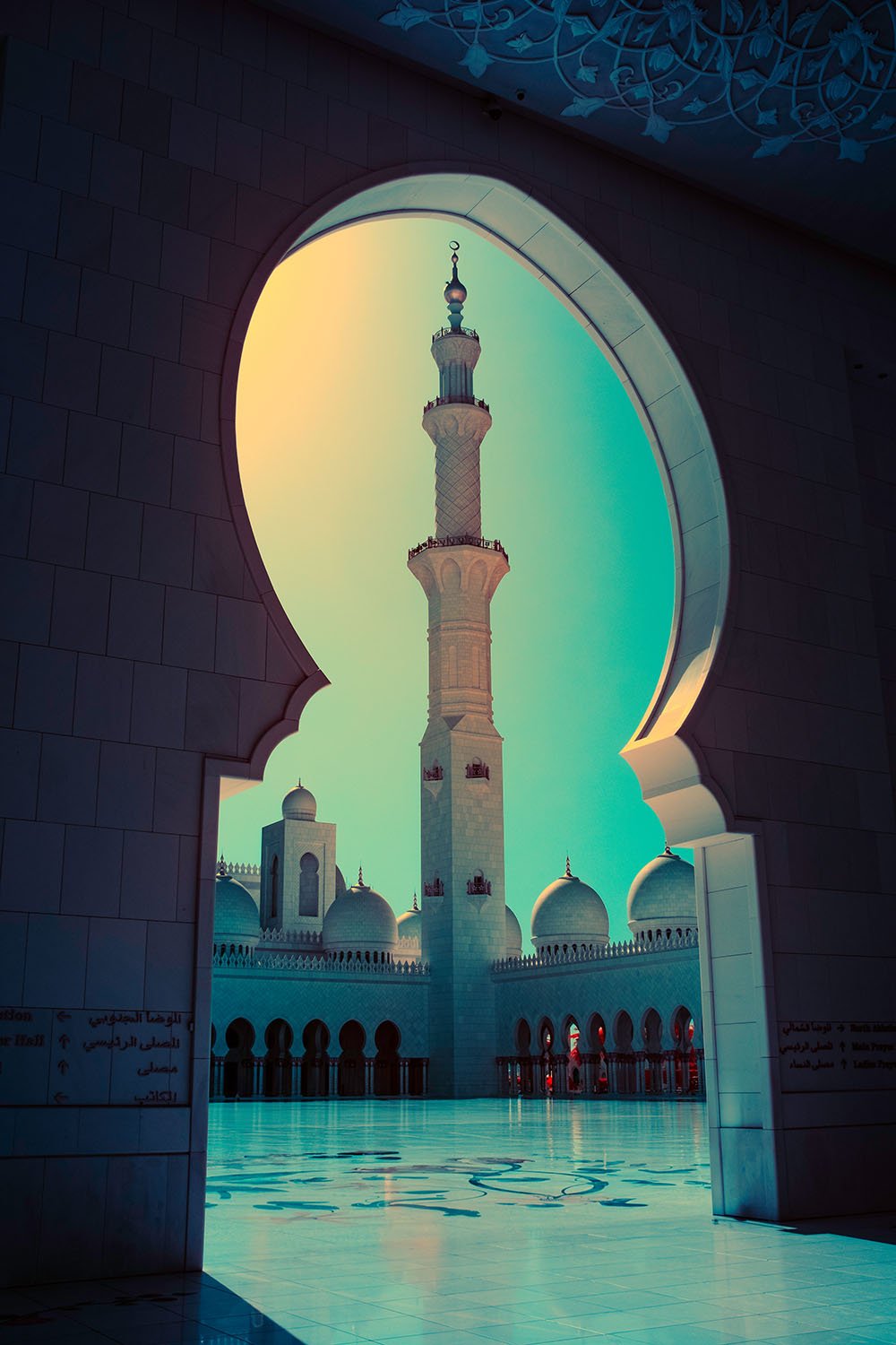 Photographie d’art infrarouge d’André Wagner: Une ouverture ornementale sombre encadre une tour claire et élancée — Sheikh Zayed Moschee 1, Vereinigte Arabische Emirate.