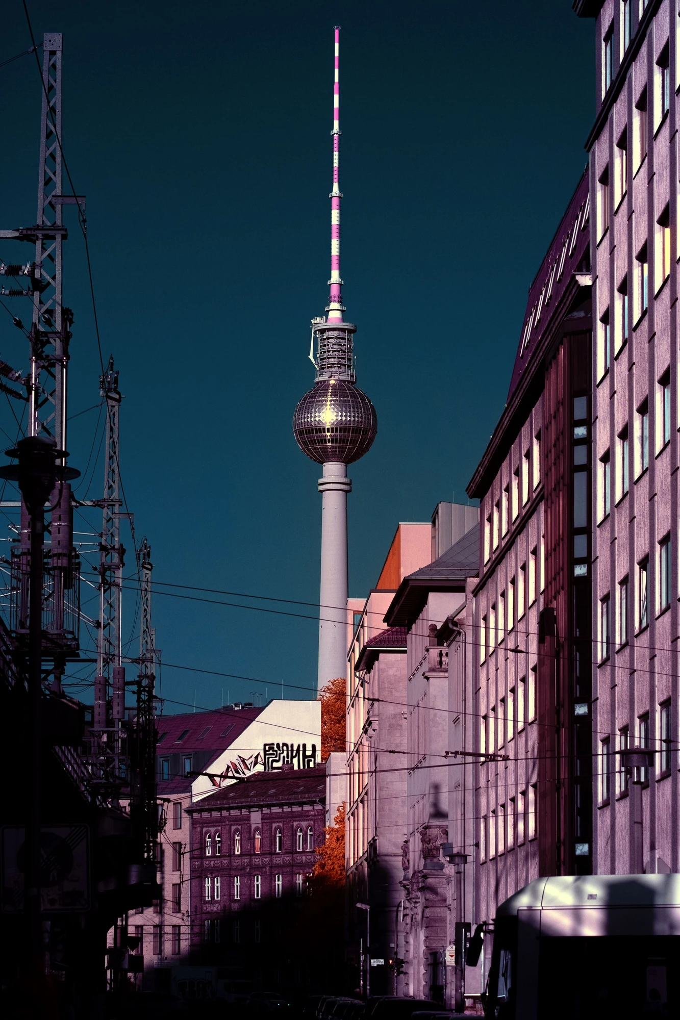 Photographie d’art infrarouge d’André Wagner: La tour de télévision de Berlin s’élève entre l’arête sombre d’un bâtiment à gauche et une longue façade vitrée à droite — Signal and Symbol.