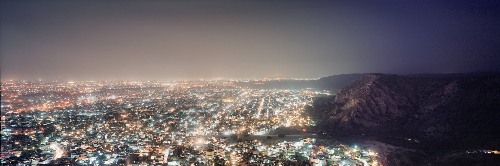 Photographie d’art d’André Wagner: Un champ dense de petites lumières emplit la plaine nocturne — Skyline of Jaipur 2.