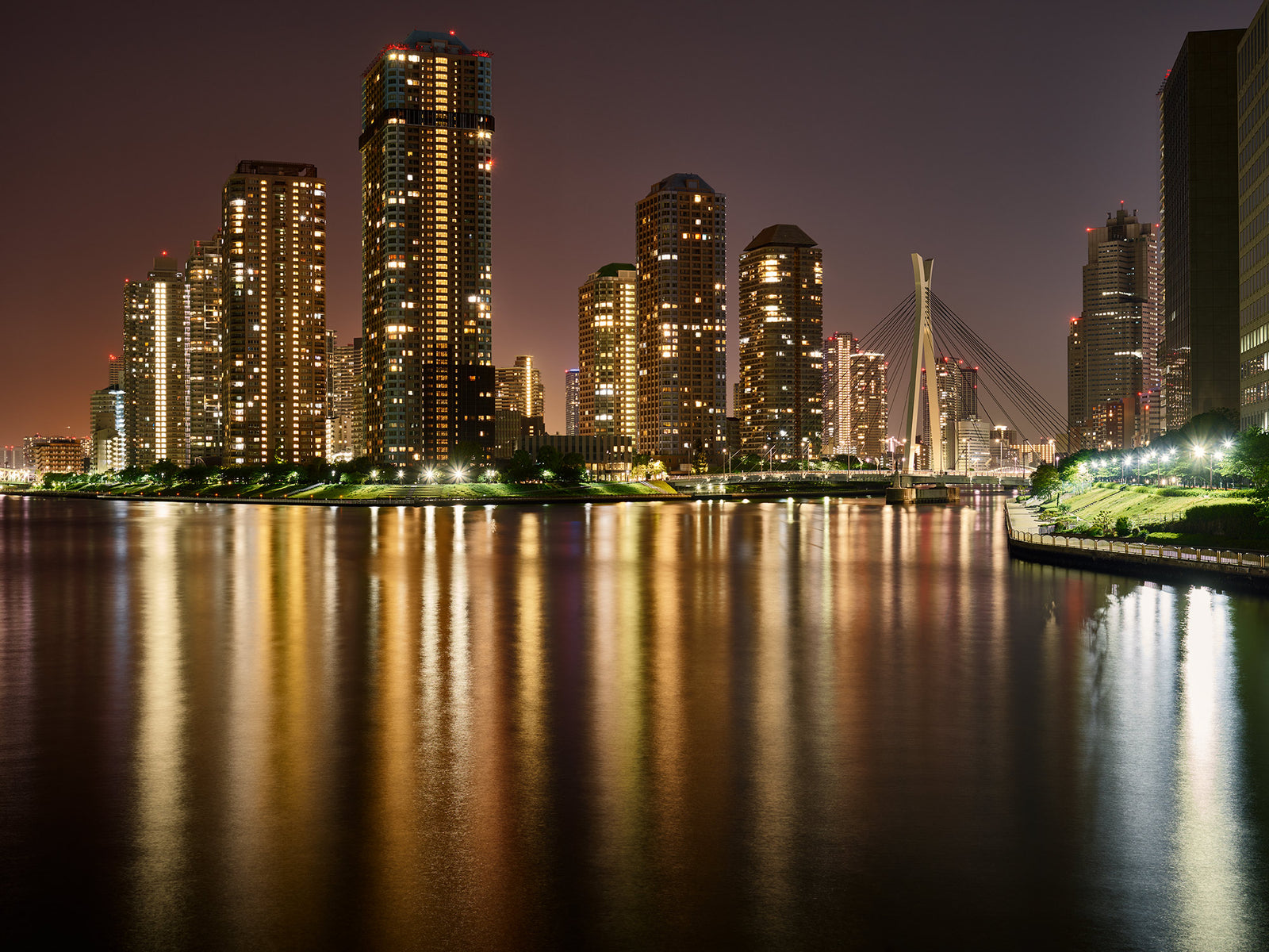 Photographie d’art d’André Wagner: De hauts bâtiments aux fenêtres nombreuses se dressent sur la rive opposée — Skyline tokyo, Japan.