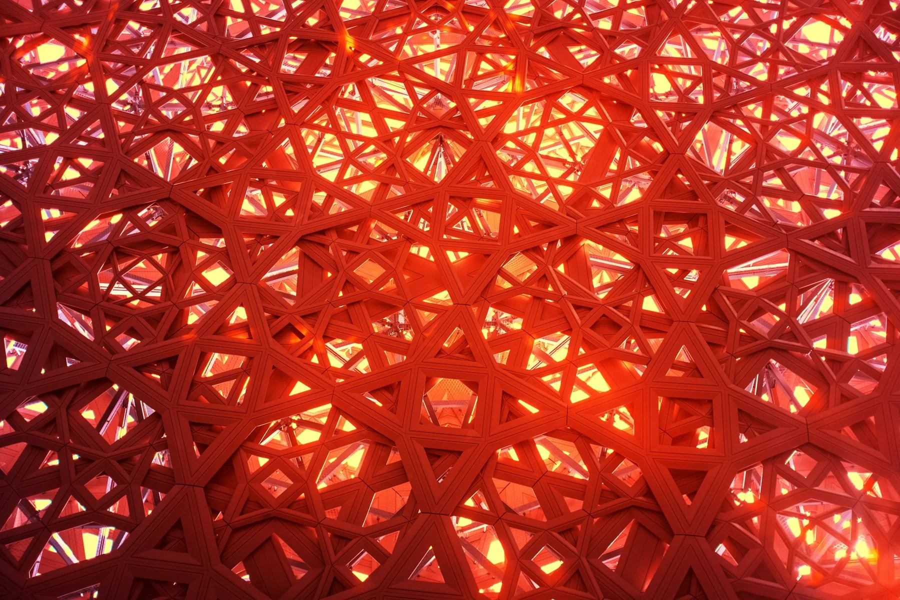 Lumière solaire à travers une fine structure géométrique de toiture.