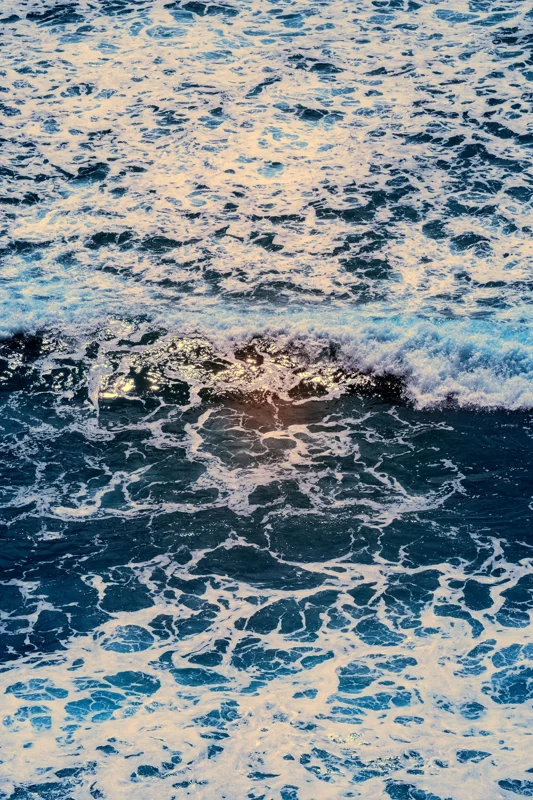 Photographie d’art infrarouge d’André Wagner: Une crête de vague claire traverse le format vertical et sépare deux réseaux d’écume de densités différentes — The Restless Sea.