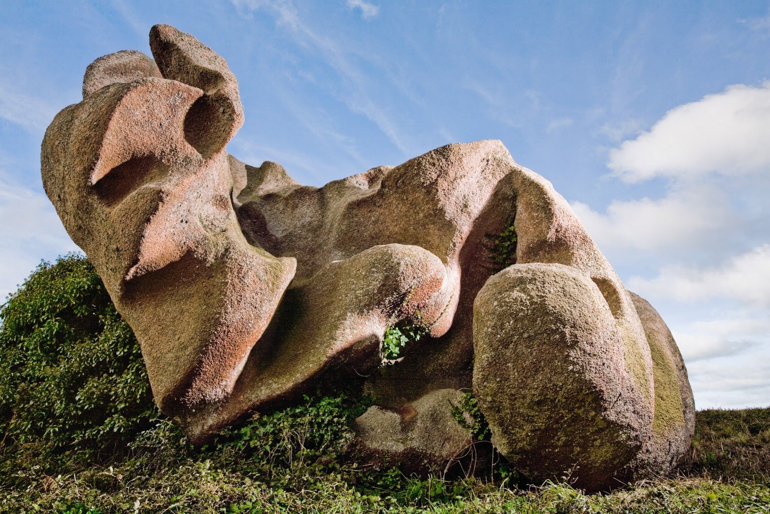 Photographie d’art d’André Wagner: De grands rochers aux cavités arrondies reposent au-dessus d’une végétation basse et verte — To Let Rest.