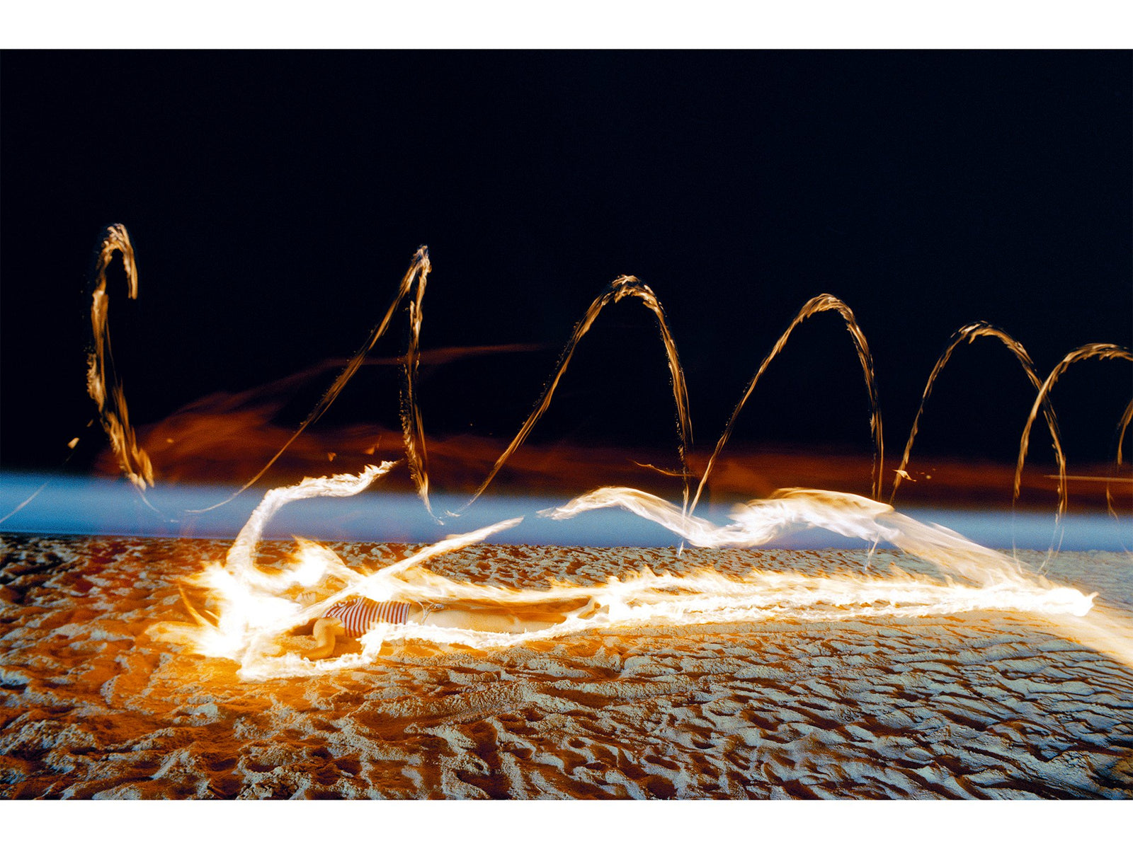 Photographie d’art d’André Wagner: Sur une plage texturée, des trajectoires de lumière claire dessinent des boucles basses — Twin souls, Spanien.