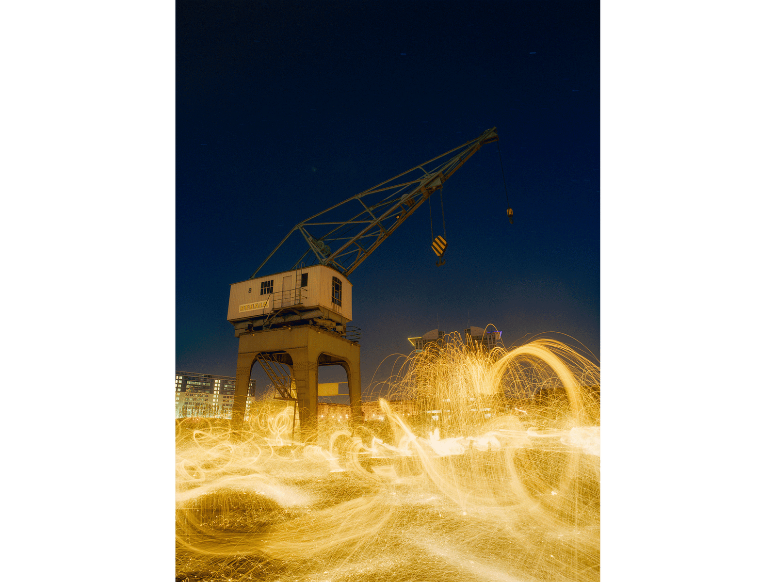 Photographie d’art d’André Wagner: Devant un ciel nocturne bleu profond, la flèche d’une grue s’élance en diagonale vers le haut à droite — Wild dance, Deutschland.
