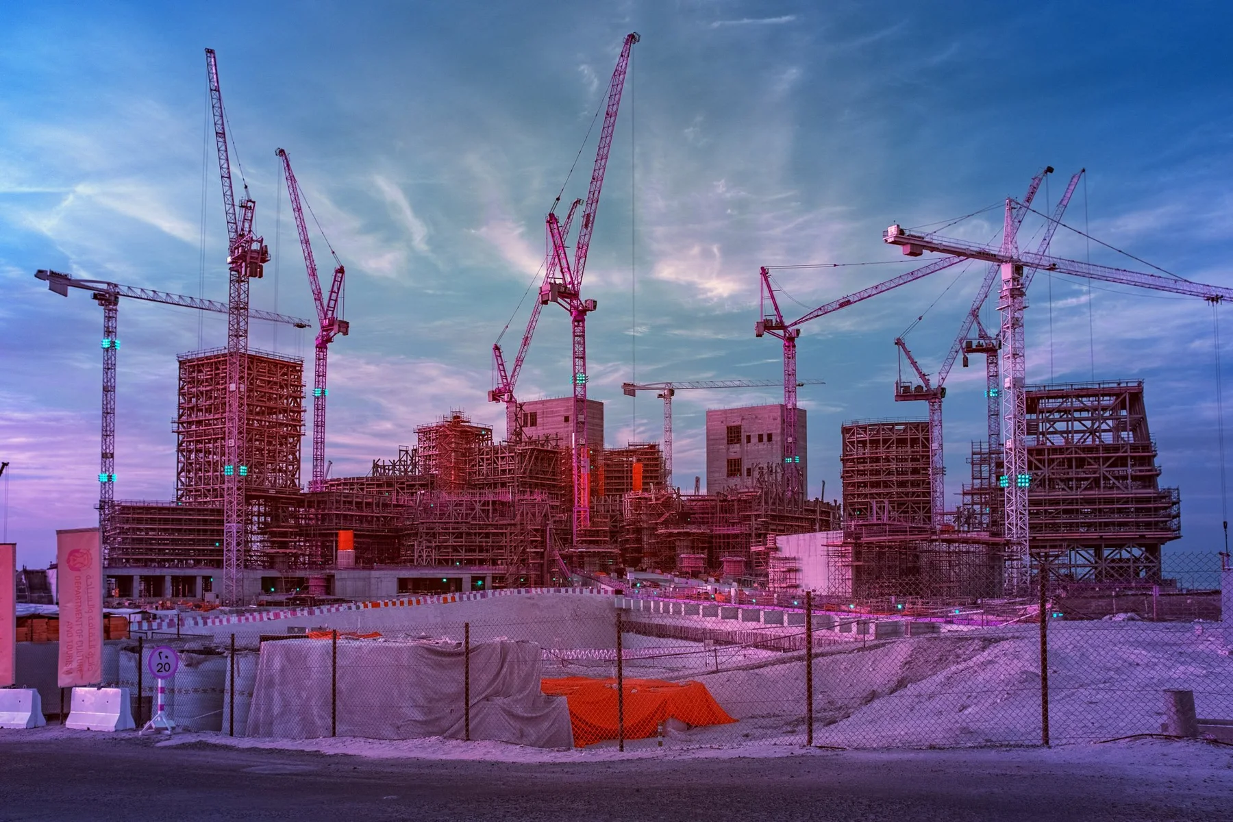 Nombreuses grues au-dessus d’un grand chantier.