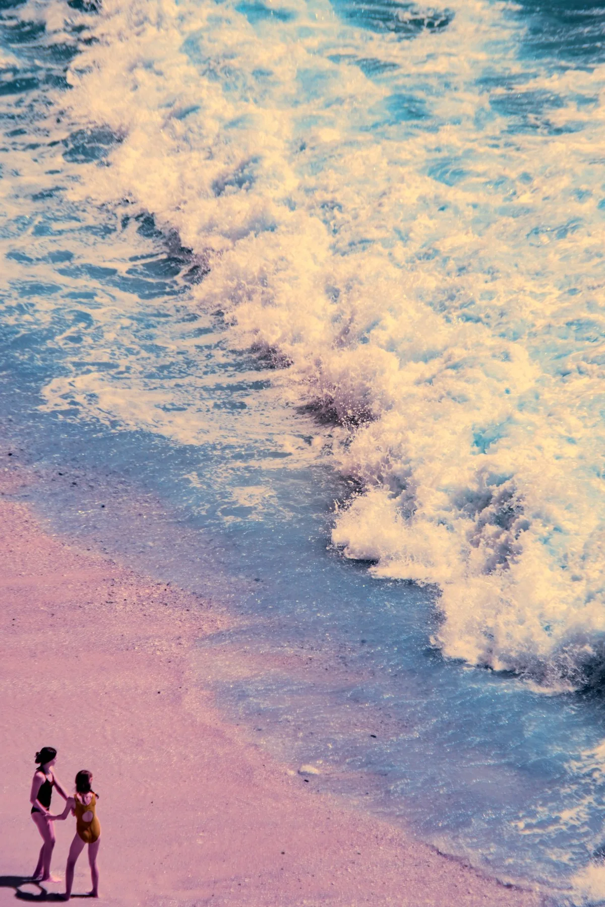 Zwei Menschen am Strand, von oben gesehen.