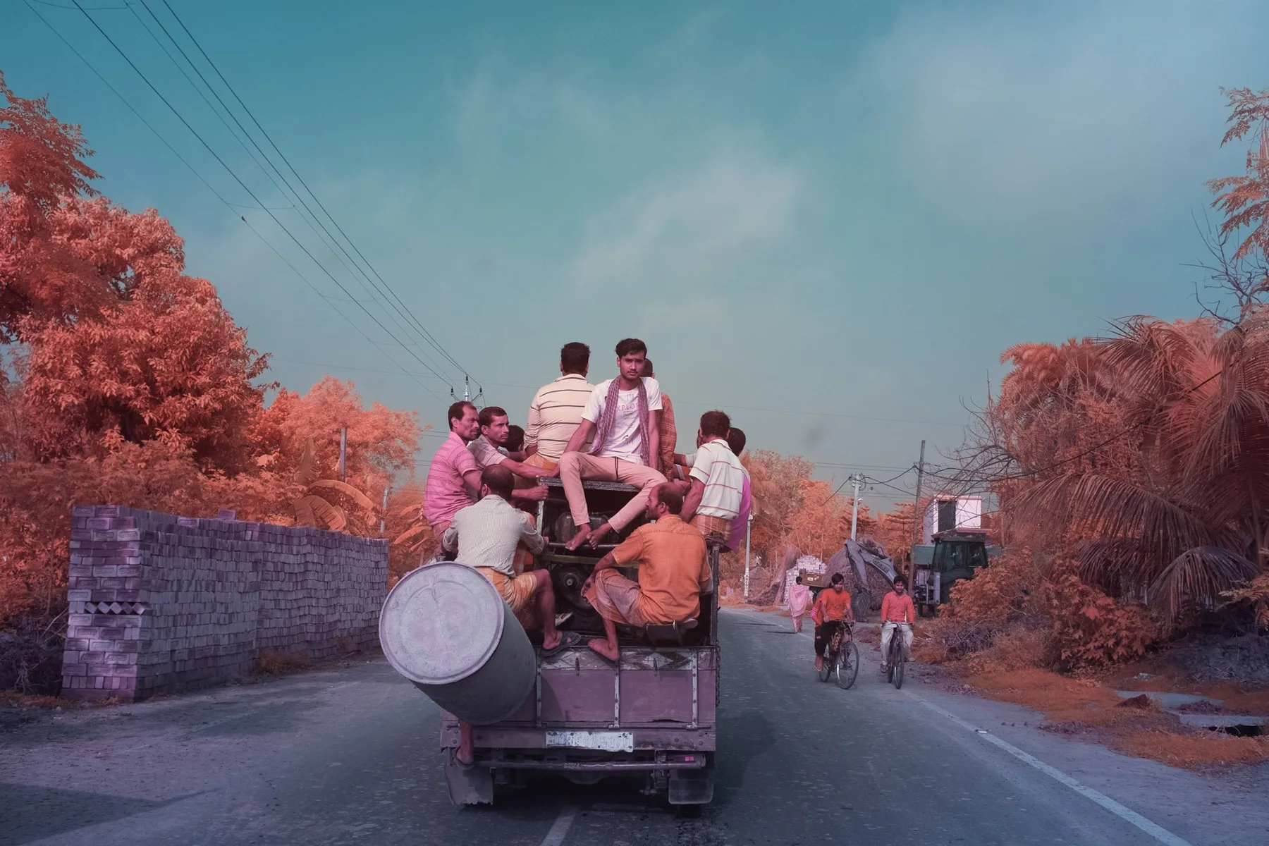 Musicians with drums on a vehicle on a road.