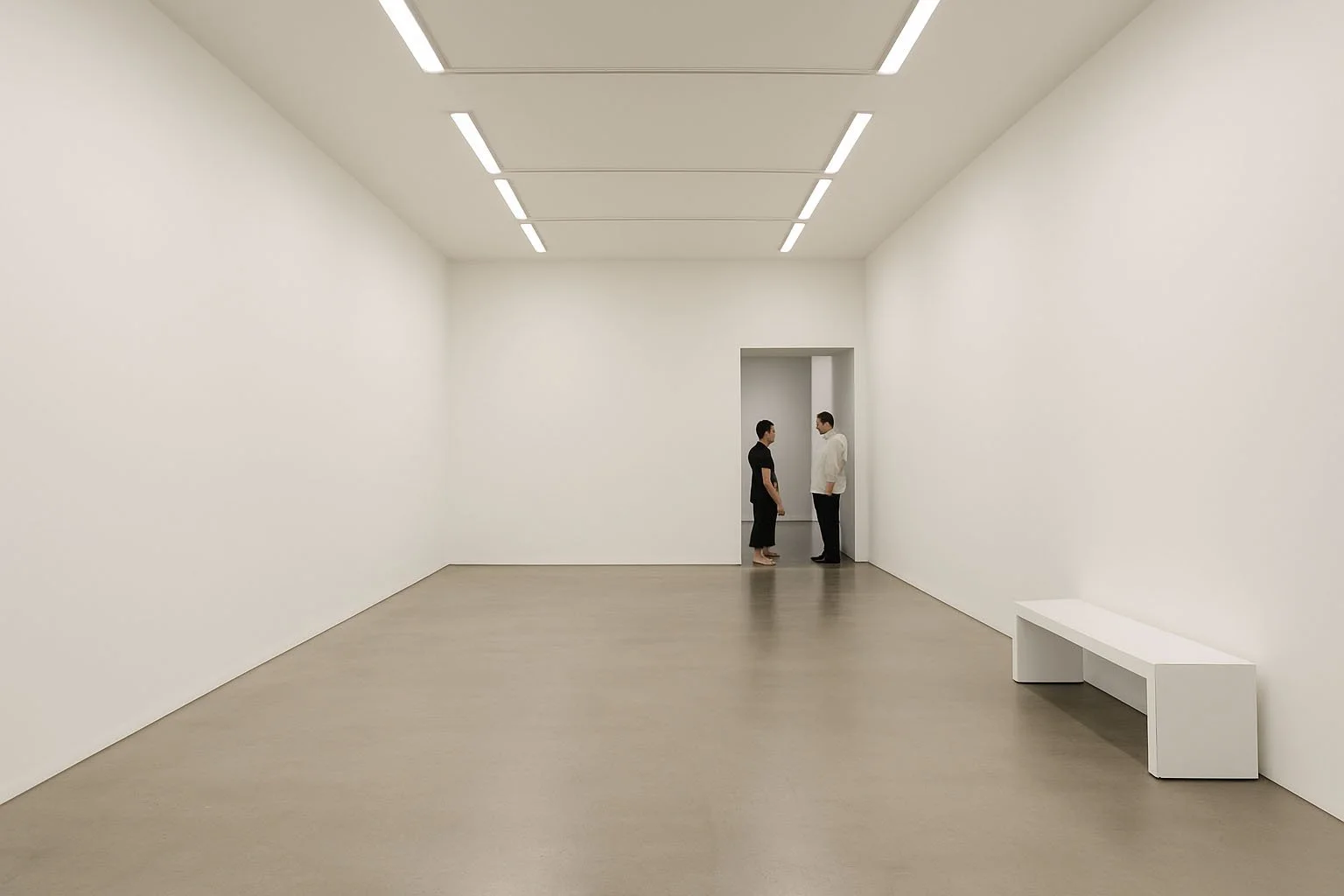 Un espace de galerie minimaliste où deux personnes échangent ; un lieu calme pour regarder les photographies contemporaines d’André Wagner.