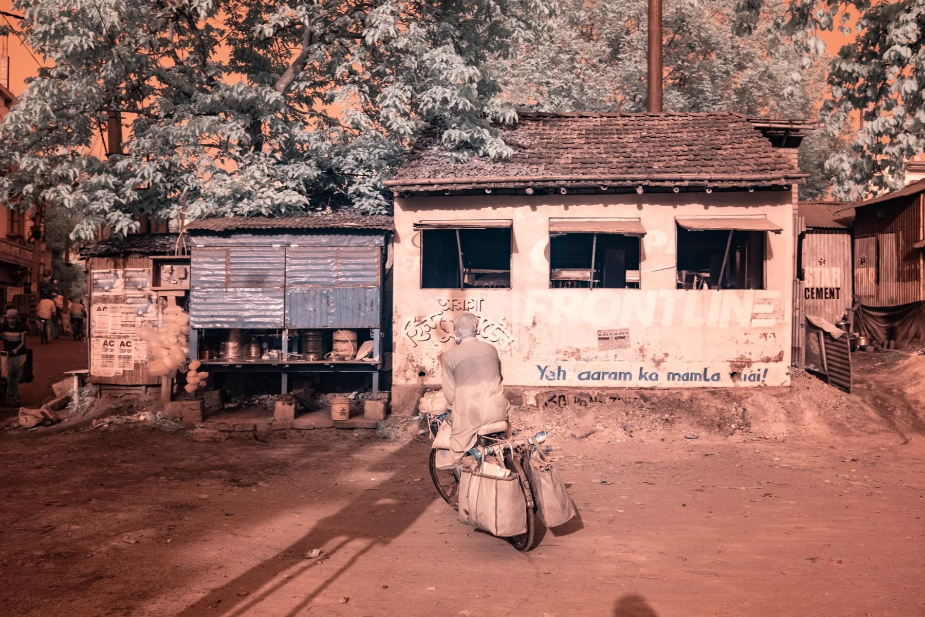 People and luggage in front of a small building.