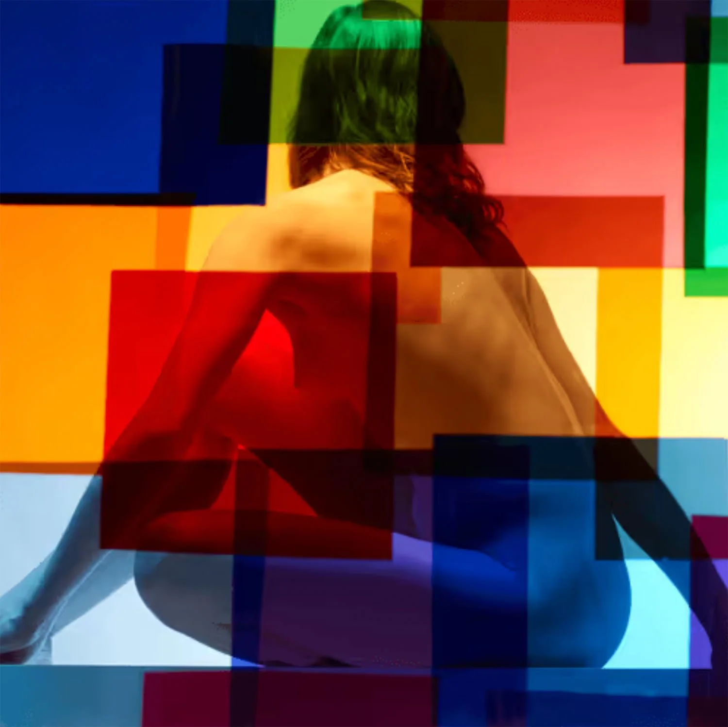 Artistic photograph of a naked woman, half covered with colorful, embossed squares that make the body partially hidden and partially visible.